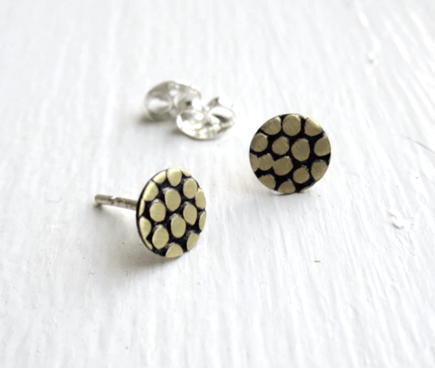 Pair of earrings displayed on a neutral background, highlighting the matte and polished finish options.