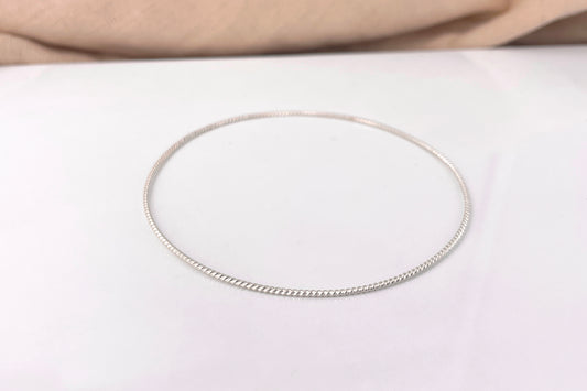 A single 1.3mm matte sterling silver twist bangle bracelet shown on a clean white surface.