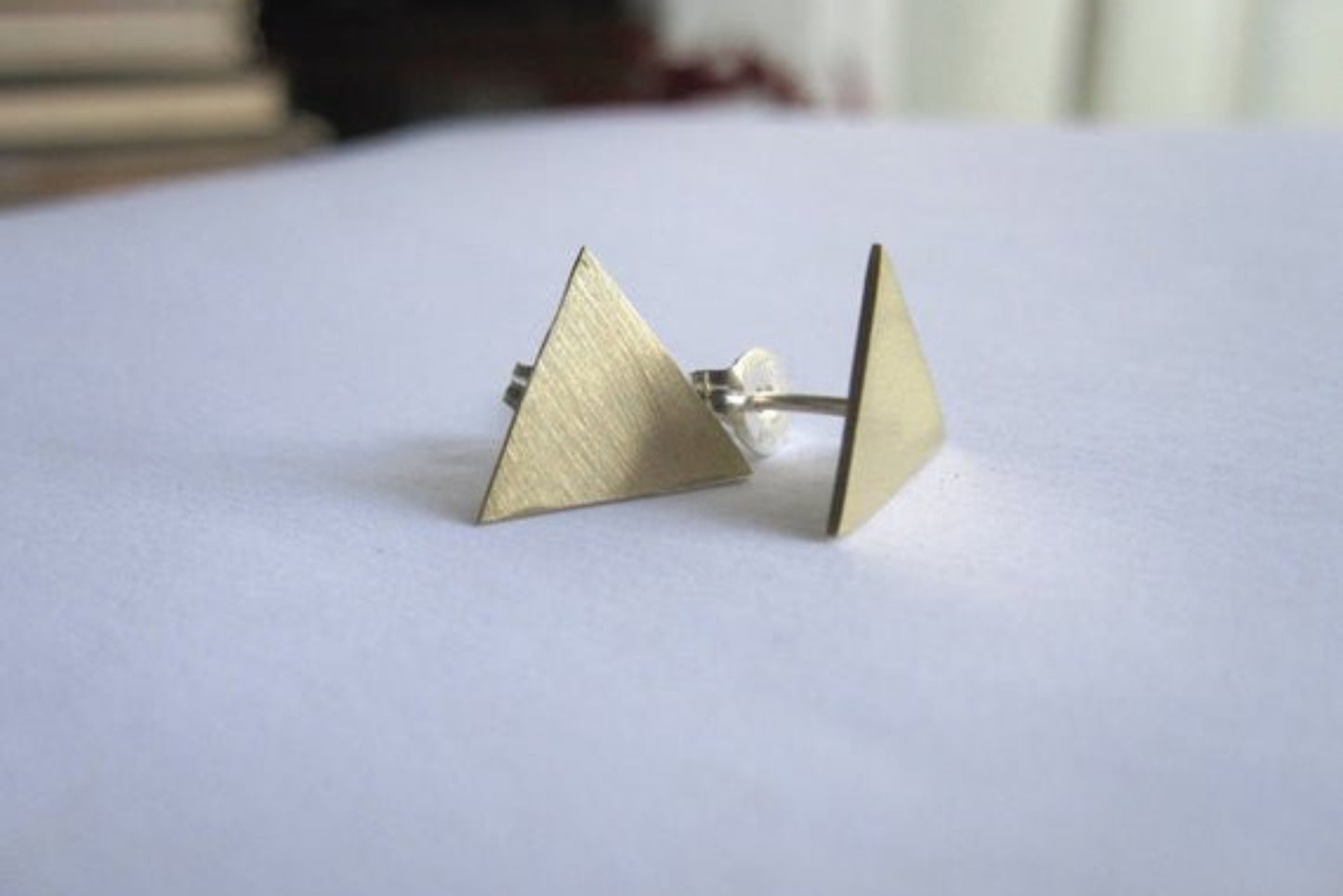 Pair of triangle-shaped earrings on a white surface