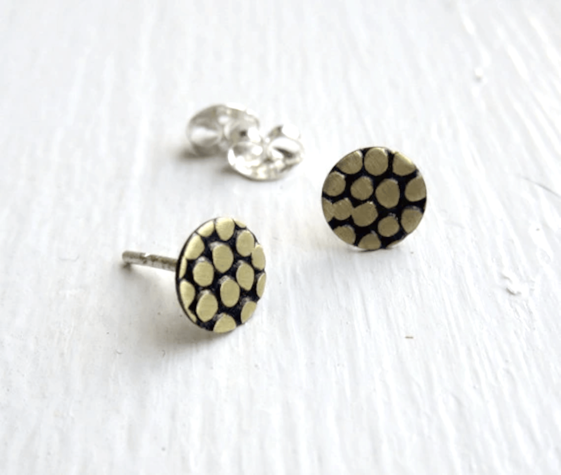 Pair of earrings displayed on a neutral background, highlighting the matte and polished finish options.