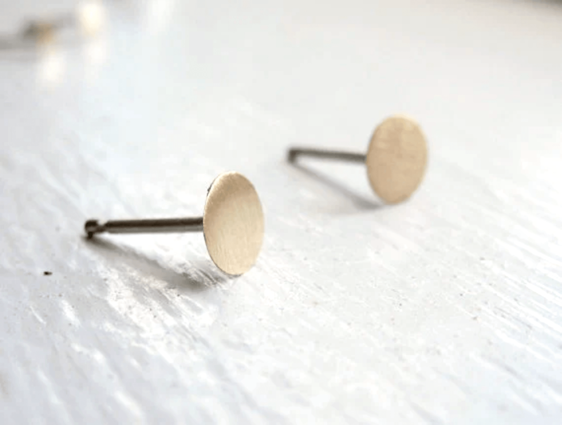 Matte finish 5mm brass circle stud earrings with sterling silver posts.